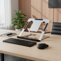Laptop stand on a desk with keyboard and mouse, plant in the background
