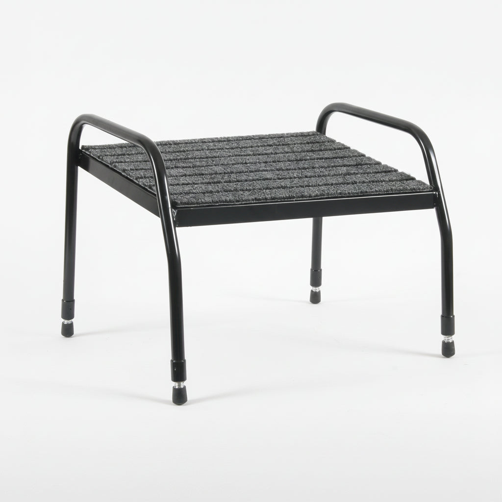 Ergonomic tall footrest with black metal frame and textured gray platform on a white background