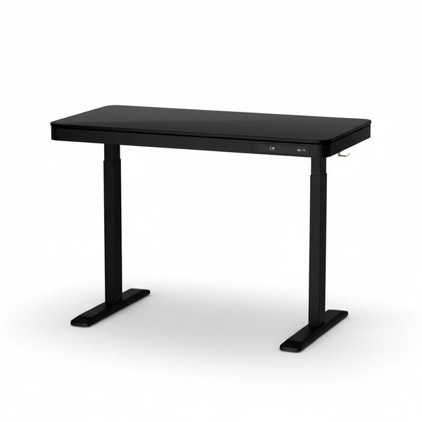 An electrically adjustable standing desk with a black tabletop and black legs, featuring a large storage drawer on the front.